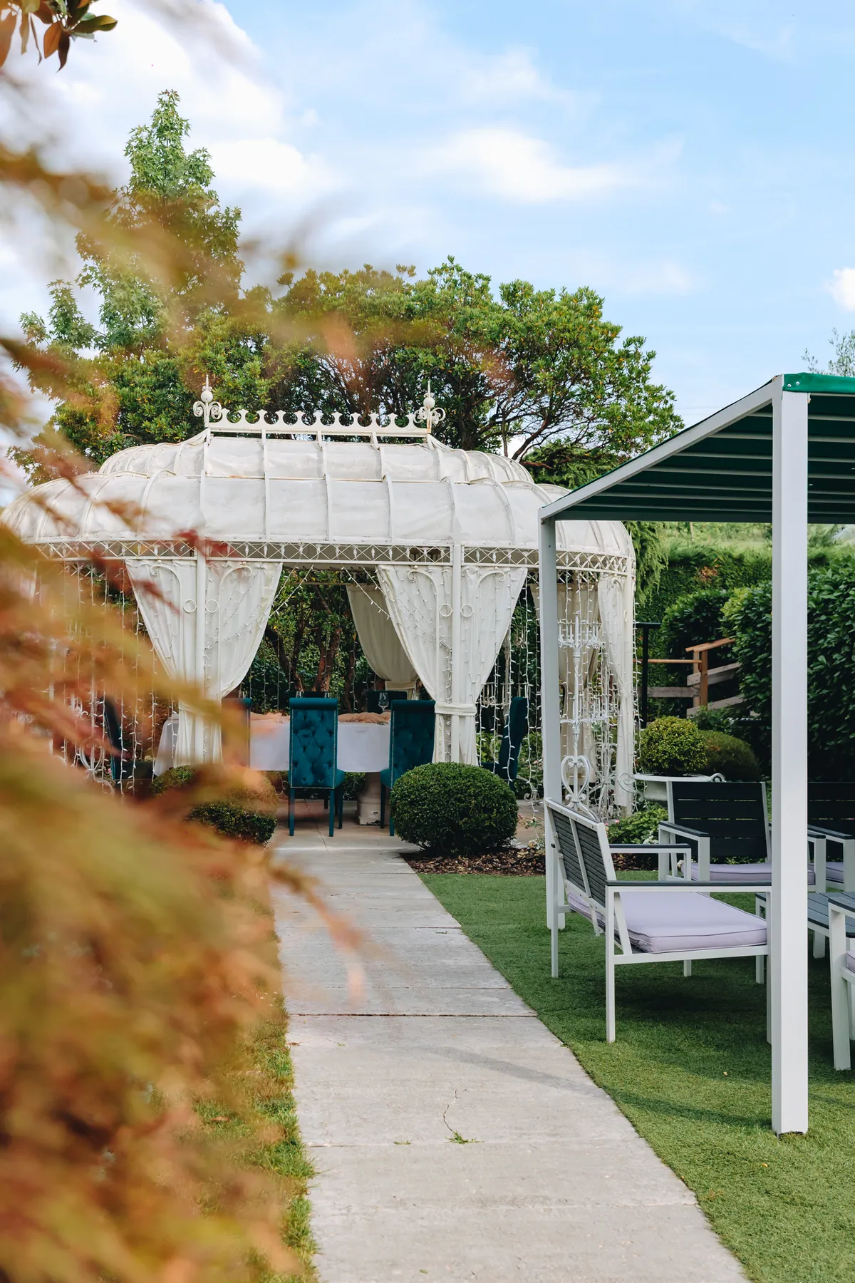 Il vialetto del giardino conduce al gazebo apparecchiato