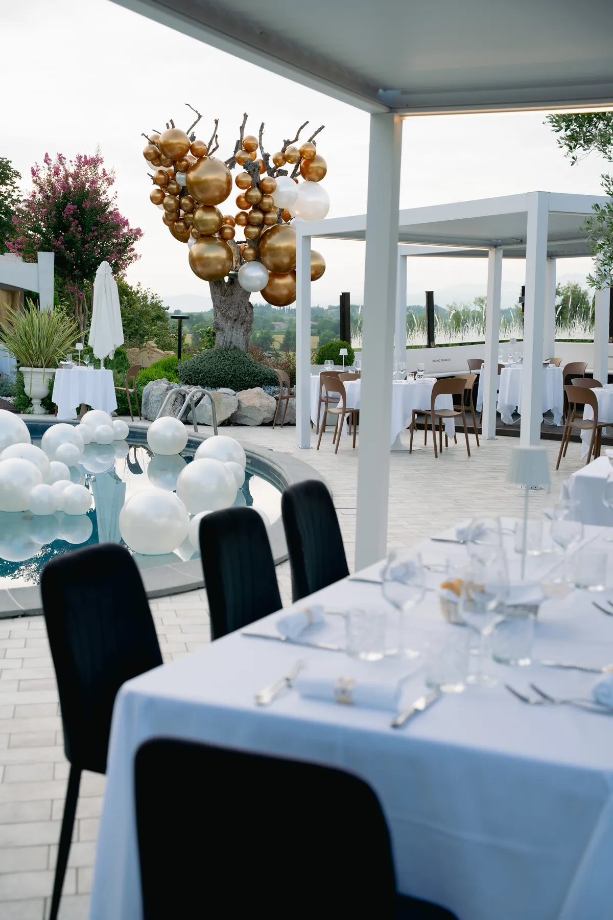 La tavola di un evento con candelabri e fiori nel giardino